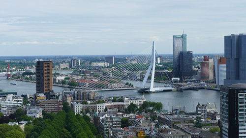 Aerial view of river amidst buildings in city against sky