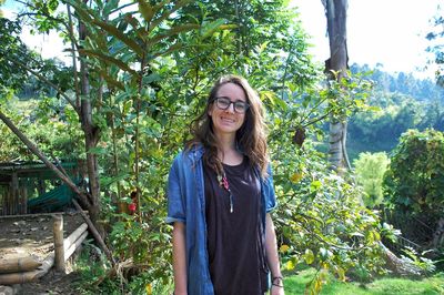 Portrait of smiling young woman standing in park