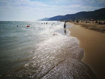 People on beach against sky