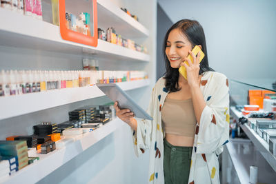 Young woman standing against store