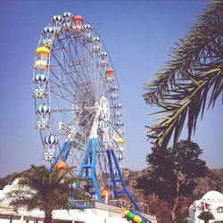 Low angle view of ferris wheel against blue sky