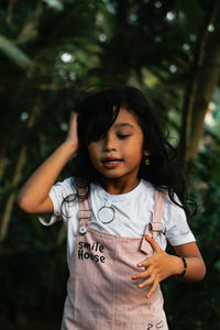 Full length of girl standing against tree