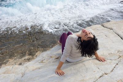 Full length of woman on rock by sea