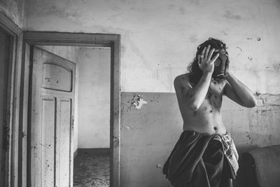 Shirtless man standing in abandoned building