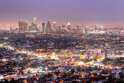 Illuminated cityscape against sky at night