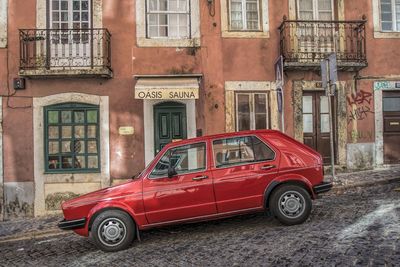 Vintage car parked on street against building in city