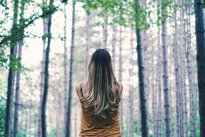 Woman standing on tree trunk