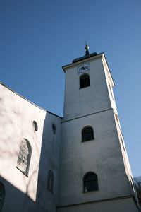 Low angle view of clock tower amidst buildings against sky