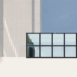 Low angle view of glass building against clear sky