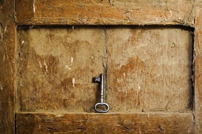 Close-up of metal key on old wooden niche