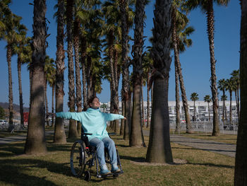 Rear view of man riding bicycle on field