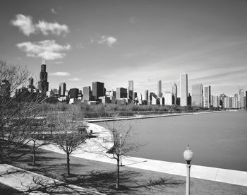 City at waterfront against cloudy sky