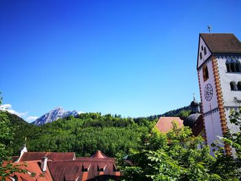 Houses and trees against clear blue sky