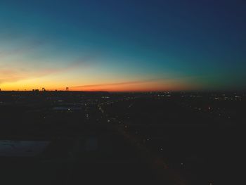 High angle view of illuminated city against sky during sunset