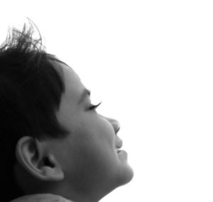 Close-up of woman holding hair over white background