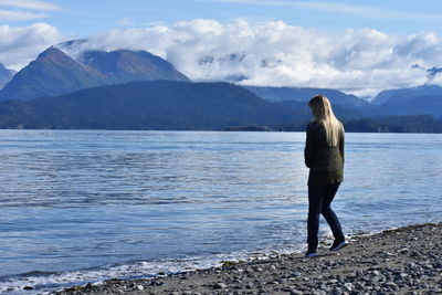 Rear view of woman looking at mountains against sky