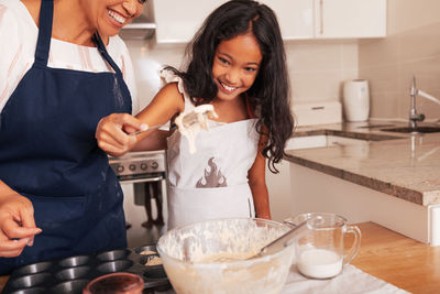 Portrait of young woman preparing food in kitchen