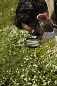 Close-up of man using magnifying glass outdoors