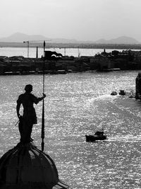 Silhouette men fishing in sea against sky