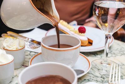 Close-up of hand holding coffee cup on table