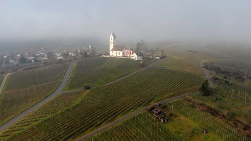 High angle view of agricultural field by buildings against sky