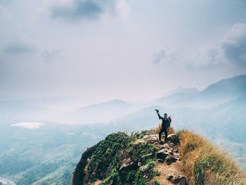 People on mountain against sky