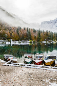 Boats moored on lake against sky