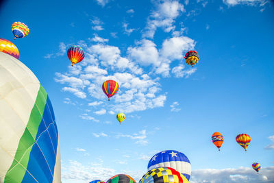 Low angle view of hot air balloons flying against sky