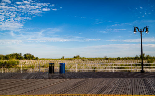 Empty wood paneled walkway against landscape