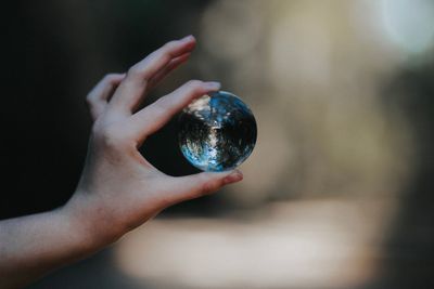 Cropped hand of woman holding crystal ball