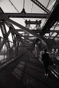 Rear view of woman walking on bridge