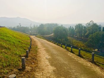 Road amidst field against sky