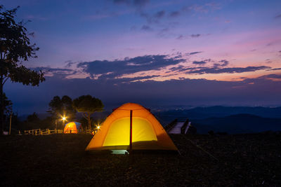 Tent on field against sky during sunset