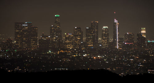 Illuminated cityscape against sky at night