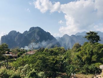 Scenic view of trees and mountains against sky