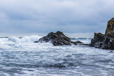 Scenic view of rocks in sea against sky