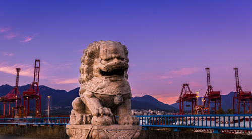 Statue by sea against sky during sunset