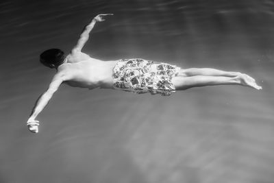 High angle view of shirtless man floating on water in sea