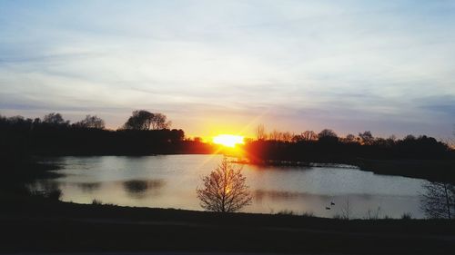 Scenic view of lake against sky during sunset