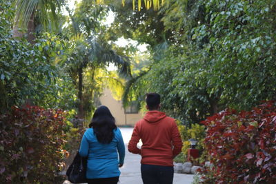 Rear view of couple walking on plants
