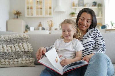 Portrait of smiling family sitting on sofa at home