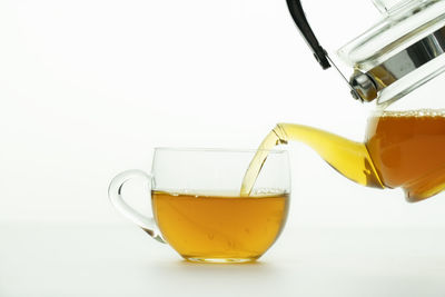 Close-up of yellow pouring over white background