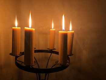 Close-up of lit candles in darkroom