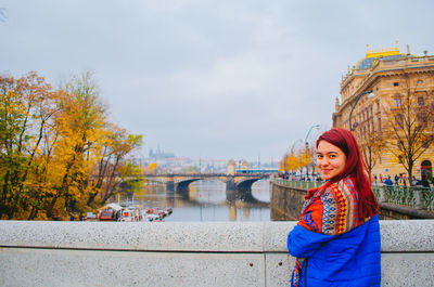 Portrait of smiling woman standing in city during autumn