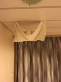 Low angle view of curtain hanging against wall