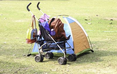 Tent by baby stroller on field