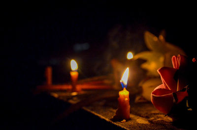 Close-up of lit candles burning in the dark