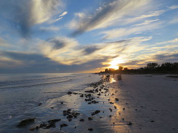 Scenic view of sea and beach against sky during sunset