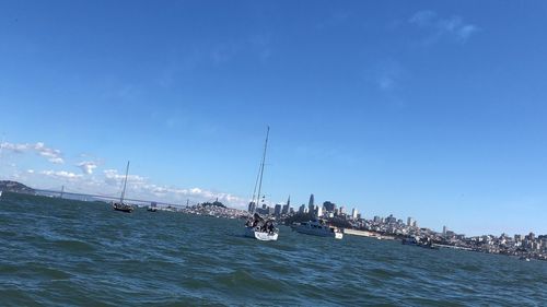 Sailboats in sea against blue sky