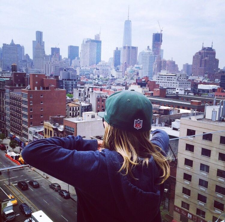 YOUNG WOMAN WITH CITYSCAPE IN BACKGROUND